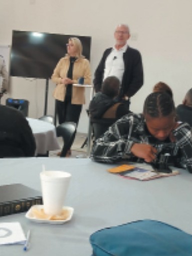A training session at the Impact Center with a speaker addressing seated attendees